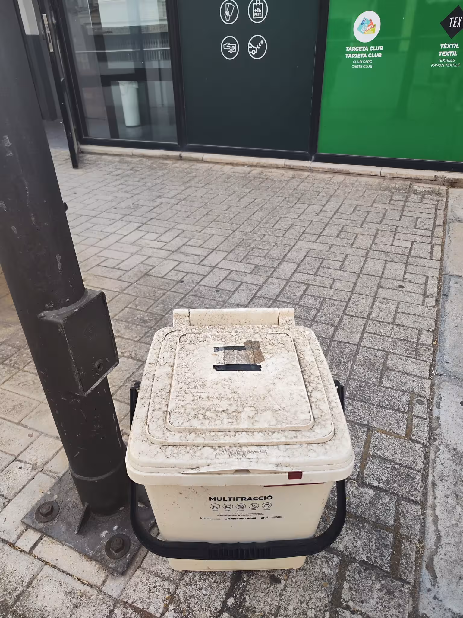 Denuncian el abandono de un cubo de recogida selectiva desde hace un mes en plena plaza Miranda de Maó