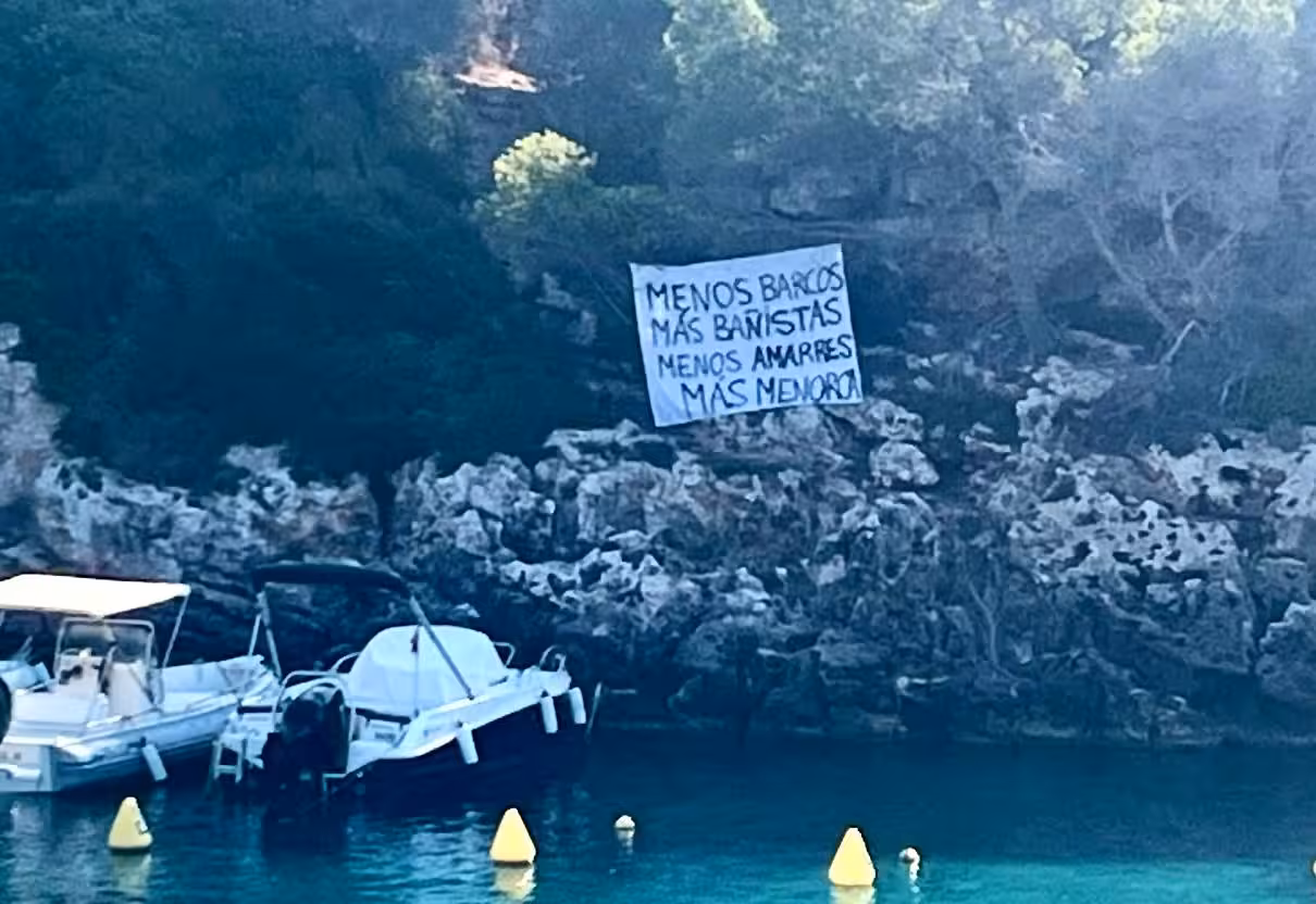 Aparece un cartel de protesta en Binisafua contra la presencia de embarcaciones: «Menos barcos, más bañistas»