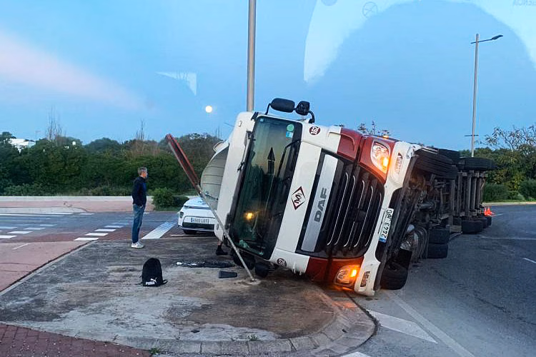 (Fotos) Un camión vuelca en la rotonda del Eroski de Sant Lluís
