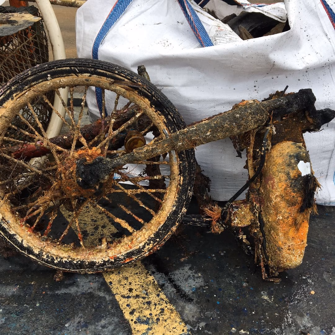 (Fotos) Extraen una moto, bicicletas y una caja fuerte de aguas de Ciutadella