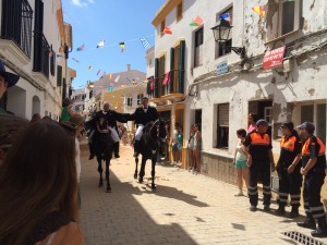 Dos jinetes, abrazados, en el centro del pueblo.