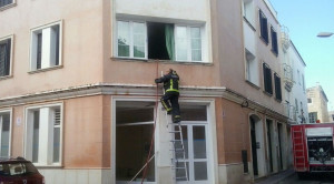 Un bombero, accediendo a la vivienda.