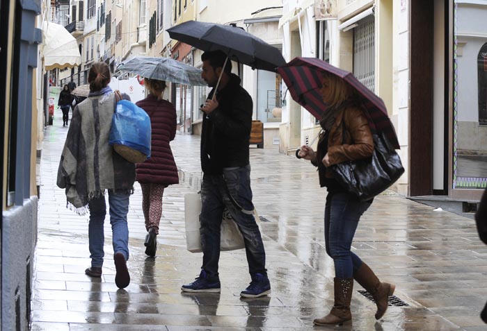 Gente con paraguas en un día de lluvia por el centro de Maó (Foto: Tolo Mercadal)