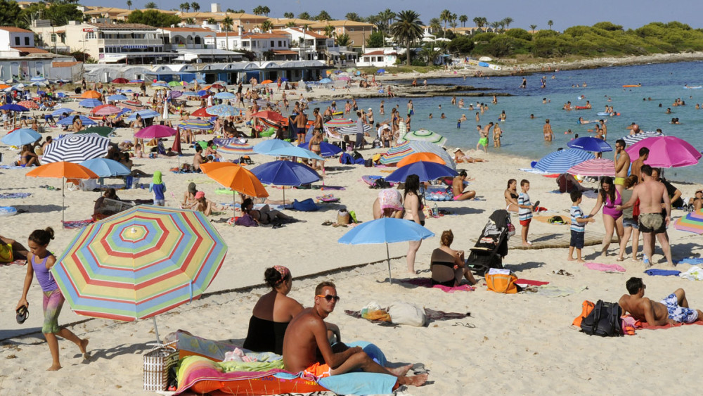 Gente en la playa de Punta Prima.