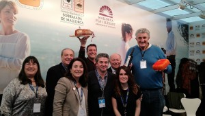 Fernando Romay con el equipo balear y sosteniendo un queso menorquín con su mano izquierda.