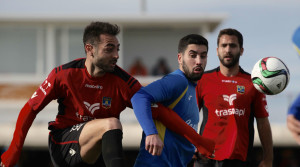 Un defensa local despeja el balón.