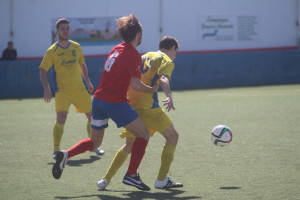 Juanfran protege el balón ante un rival (Fotos: futbolbalear.es)