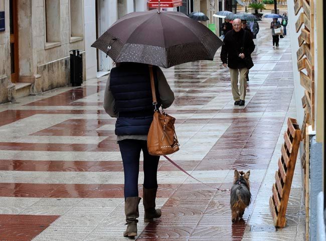 Gente con paraguas en Maó.