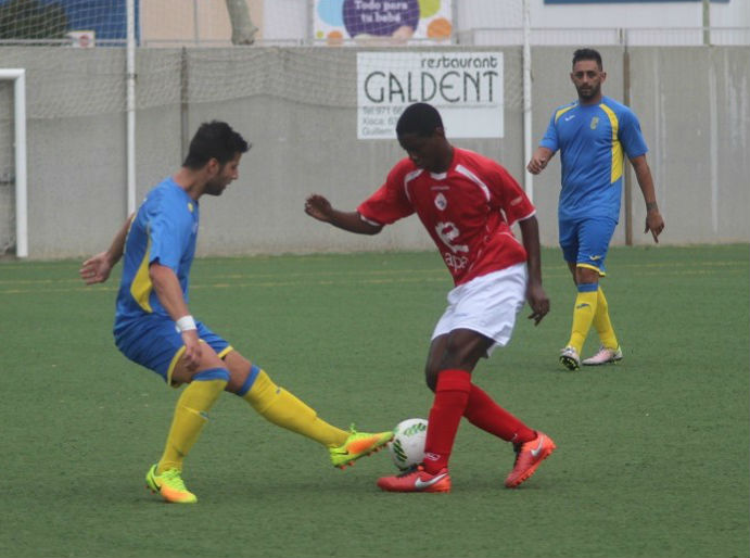 Llonga trata de frenar el avance de un rival durante el partido (Fotos: futbolbalear.es)