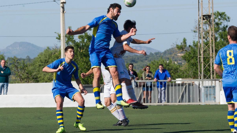 Biel Medina despeja un balón ante un delantero del Felanitx (Fotos. futbolbalear.es)