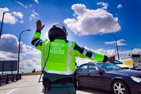 Un Guardia Civil de tráfico detiene a un vehículo.