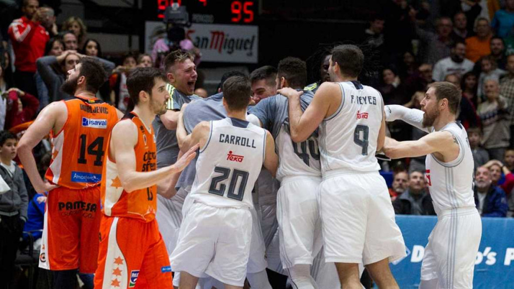 Jugadores del Real Madrid abrazando a Llull tras el triple.