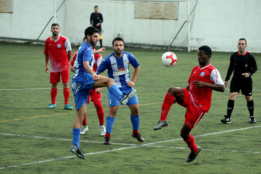 Juan Carlos se lleva el balón ante un jugador del Murense (Foto: deportesmenorca.com)