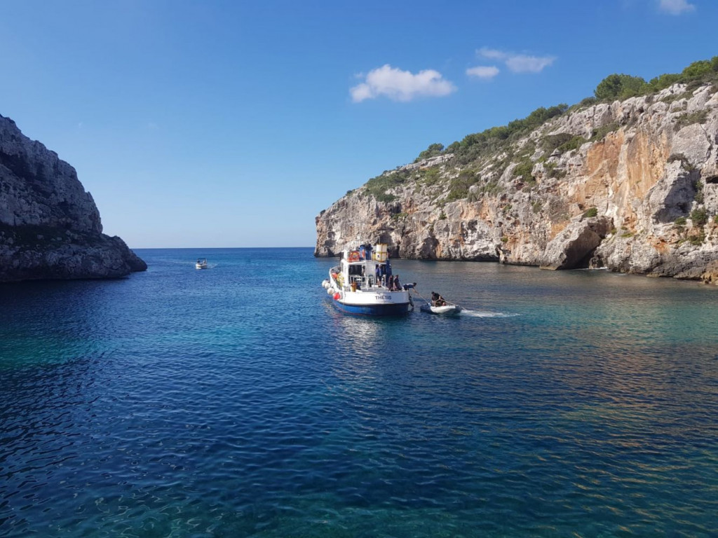 El barco Thetis trabajando en Cales Coves