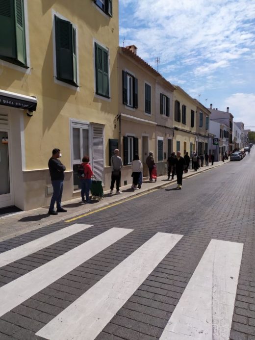 Las personas guardan la cola a la entrada de los supermercados