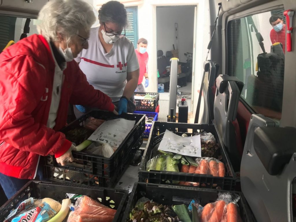 Voluntarios de la Cruz Roja repartiendo alimentos.