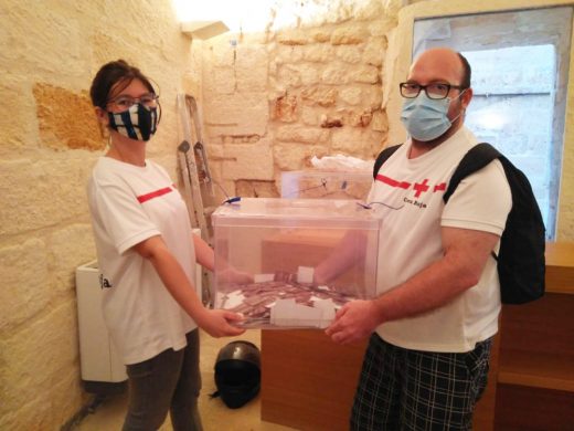 Voluntarios de la Cruz Roja con la urna de las papeletas para la rifa