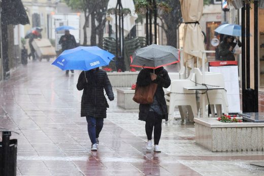 Gente con paraguas en el centro de Maó (Foto: Tolo Mercadal)