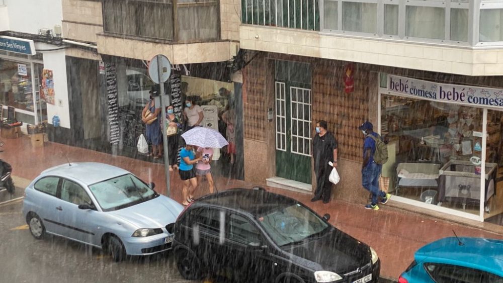 Gente se protege de la lluvia en Maó (Foto: Tolo Mercadal)