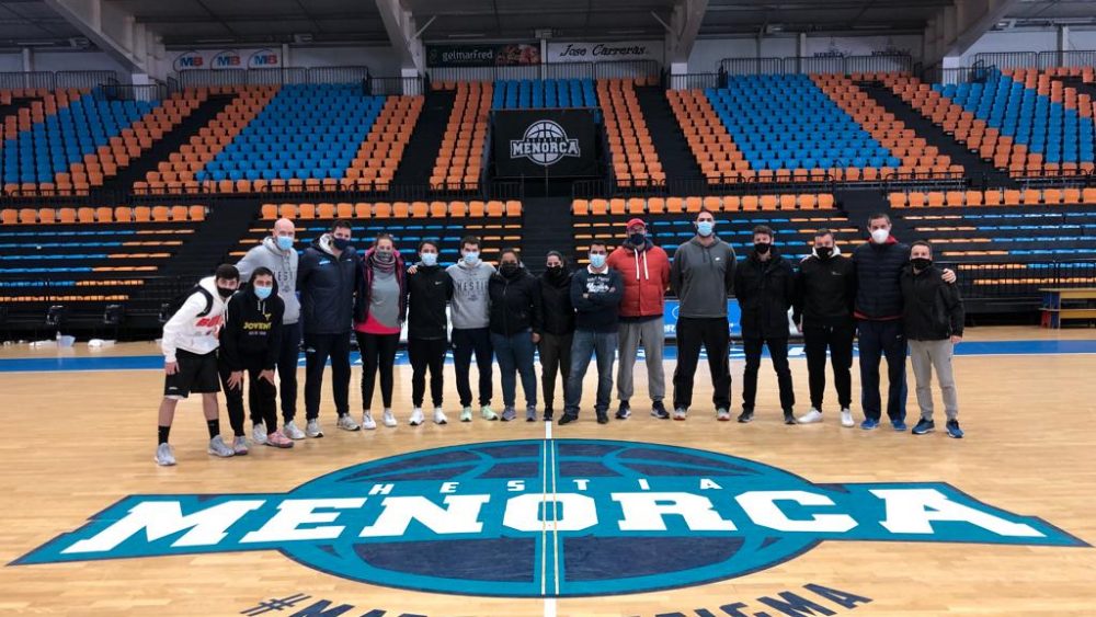 Los entrenadores de Menorca, junto al staff técnico del Hestia en el centro de la pista.