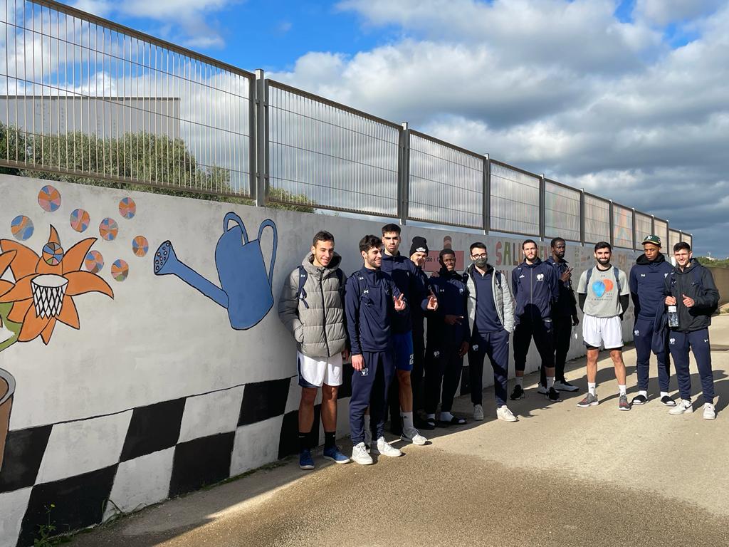 Los jugadores del Cornellà, ante el mural (Fotos: Bàsquet Menorca)