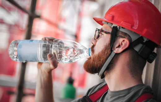 Un operario se refresca con agua.