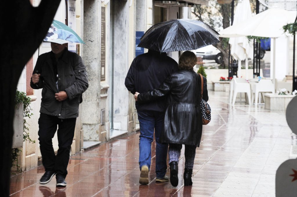 Gente con paraguas en Maó.