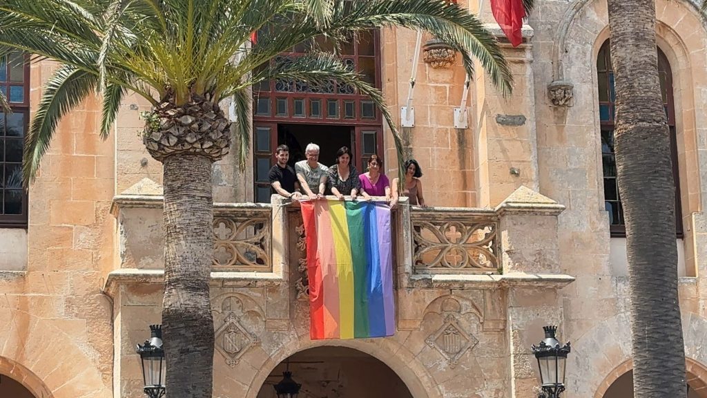 Juana Mari Pons junto a su equipo colgando la bandera LGTBI en el balcón del Ayuntamiento